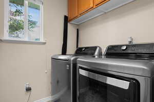 Laundry area featuring cabinets and washing machine and clothes dryer