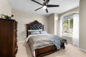Carpeted bedroom featuring ceiling fan