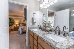 Primary Bathroom with double vanity, a sink, and connected bathroom