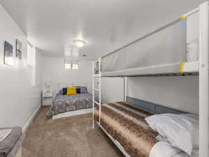 Bedroom with a textured ceiling and carpet flooring