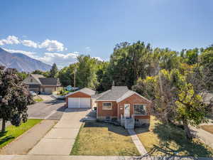 View of front of house with a garage, a front yard, and a mountain view