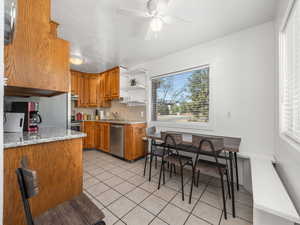 Kitchen featuring ceiling fan, sink, decorative backsplash, light stone countertops, and appliances with stainless steel finishes