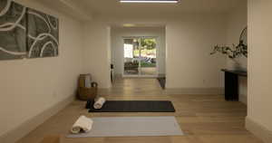 Exercise room with light hardwood / wood-style floors