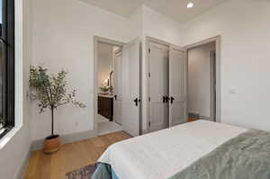 Bedroom featuring light hardwood / wood-style floors and ensuite bath