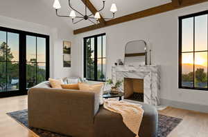 Living room featuring a healthy amount of sunlight, a fireplace, hardwood / wood-style floors, and an inviting chandelier