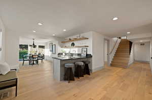 Kitchen featuring pendant lighting, a breakfast bar area, light hardwood / wood-style flooring, and kitchen peninsula