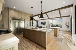 Kitchen with decorative light fixtures, appliances with stainless steel finishes, vaulted ceiling with beams, and a spacious island