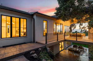 Back house at dusk featuring a patio