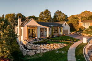 Ranch-style home with a mountain view, a garage, and a front lawn