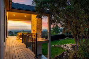 Deck at dusk featuring a lawn