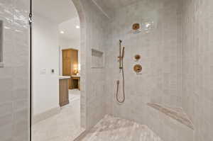 Bathroom featuring a tile shower and vanity