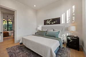 Bedroom with a chandelier and light wood-type flooring