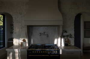 Kitchen featuring black range with gas cooktop, hardwood / wood-style flooring, and gray cabinetry