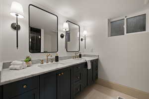 Bathroom featuring walk in shower, vanity, and tile patterned floors