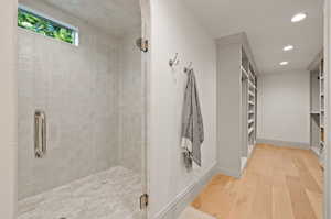 Bathroom featuring walk in shower and wood-type flooring