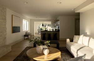 Living room with wood-type flooring and a stone fireplace