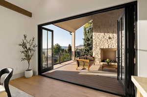 Doorway with lofted ceiling, a mountain view, and light hardwood / wood-style floors