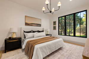 Bedroom with a notable chandelier, multiple windows, and light hardwood / wood-style flooring