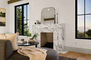 Sitting room with hardwood / wood-style flooring and a premium fireplace