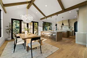 Dining room featuring light hardwood / wood-style floors, high vaulted ceiling, beam ceiling, and a chandelier