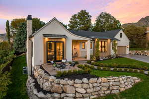 View of front of property featuring a garage, a patio, a lawn, and a mountain view