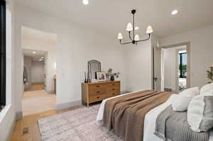 Bedroom featuring light hardwood / wood-style floors and a chandelier