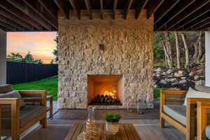 Patio terrace at dusk with an outdoor stone fireplace