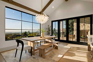 Dining room featuring an inviting chandelier, beamed ceiling, light hardwood / wood-style floors, and high vaulted ceiling