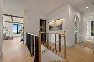 Hallway featuring beam ceiling and light hardwood / wood-style flooring