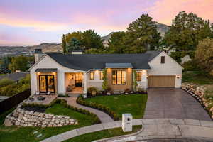 Modern farmhouse style home with a yard, a mountain view, covered porch, and a garage