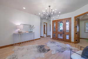 Entryway featuring an inviting chandelier, light hardwood / wood-style flooring, and a wealth of natural light