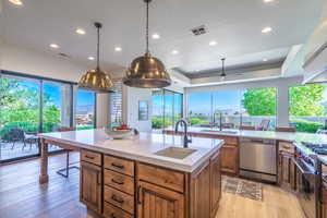 Kitchen with light hardwood / wood-style flooring, a center island with sink, appliances with stainless steel finishes, and sink