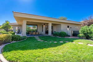 Rear view of property with a yard and a patio area