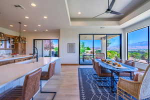 Kitchen with a mountain view, light wood-type flooring, pendant lighting, ceiling fan, and sink