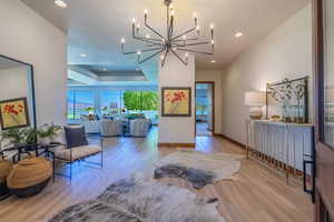 Living room with light wood-type flooring and an inviting chandelier