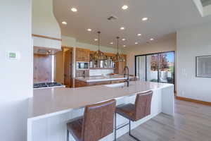 Kitchen featuring built in microwave, tasteful backsplash, sink, kitchen peninsula, and a kitchen bar