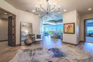 Hall with an inviting chandelier and hardwood / wood-style flooring