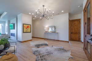 Interior space featuring light wood-type flooring and an inviting chandelier