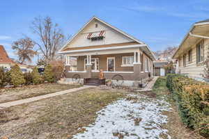 Bungalow-style house with covered porch and a lawn