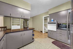 Kitchen featuring gray cabinetry, light tile patterned floors, and white oven