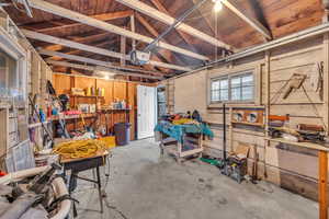 Garage with a garage door opener, wood walls, and a workshop area