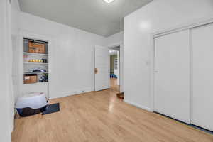 Bedroom featuring a closet, light hardwood / wood-style flooring, and a textured ceiling