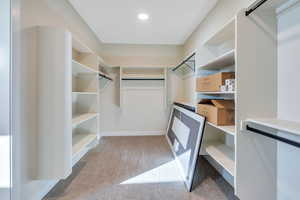 Walk in closet with carpet and a barn door