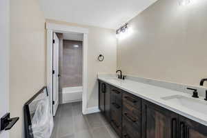 Bathroom with vanity, tile patterned floors, and a textured ceiling