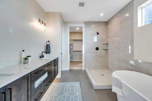 Bathroom featuring separate shower and tub, vanity, and tile patterned flooring