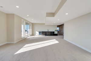 Unfurnished living room featuring light carpet