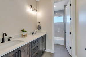 Bathroom featuring a bath, tile patterned flooring, and vanity