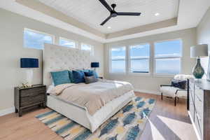 Bedroom featuring a raised ceiling, ceiling fan, wood ceiling, and light hardwood / wood-style floors