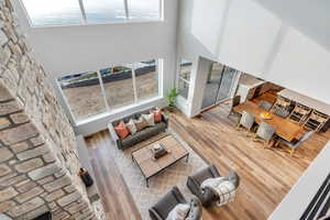 Living room with a high ceiling and light hardwood / wood-style flooring