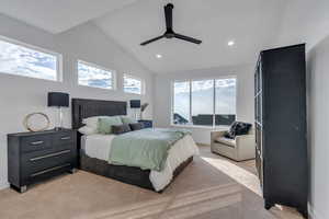 Bedroom with ceiling fan, light colored carpet, and lofted ceiling